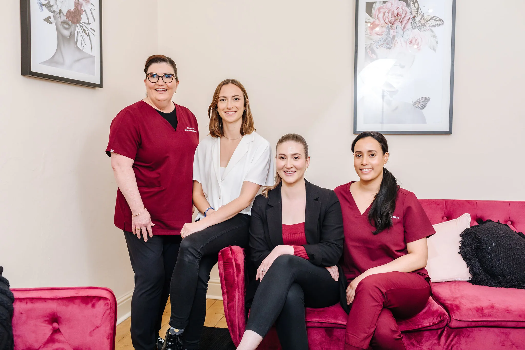 The four Embrace Aesthetics team members on the raspberry velvet lounge in the Hawthorn clinic